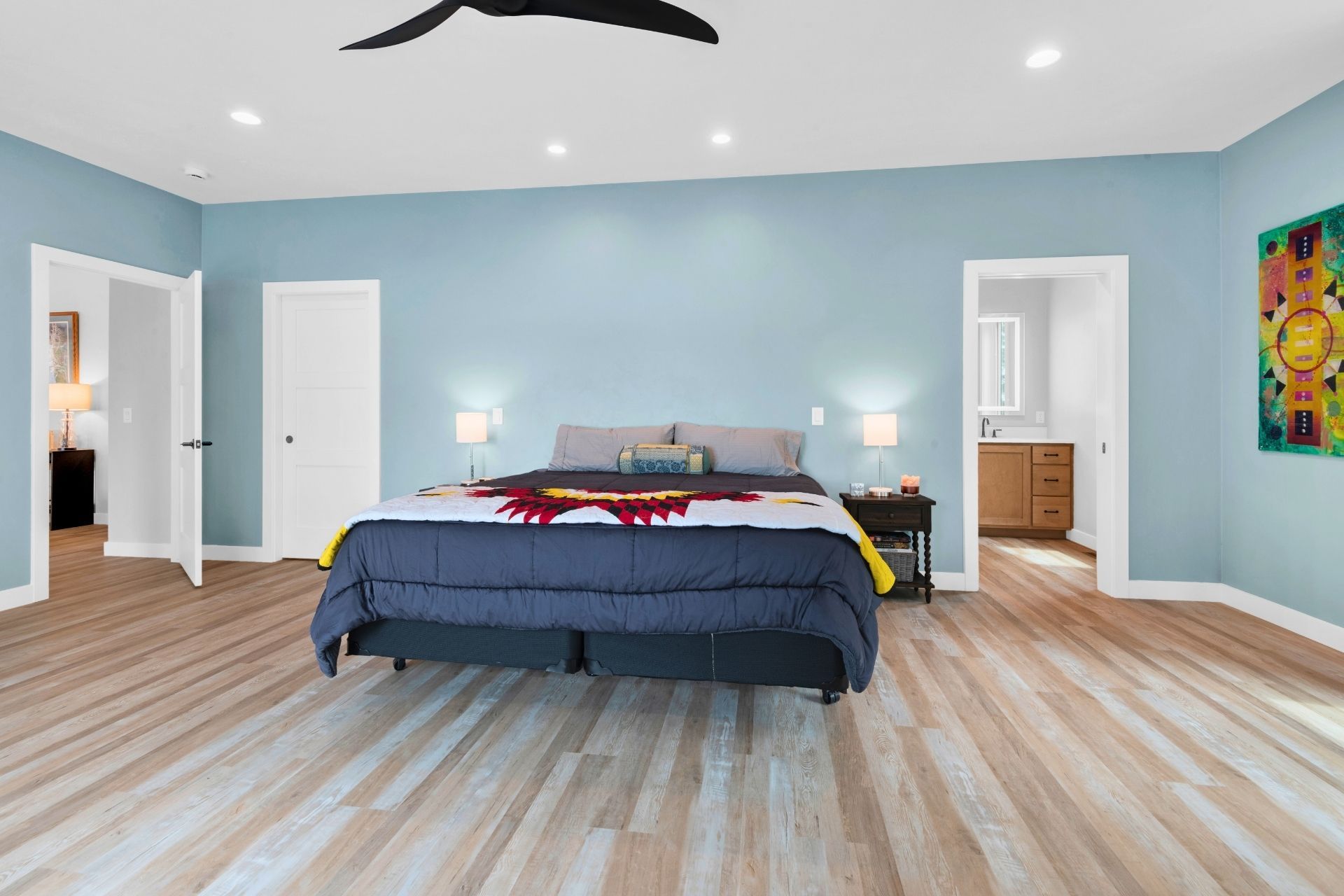A bedroom with a large bed and a ceiling fan.