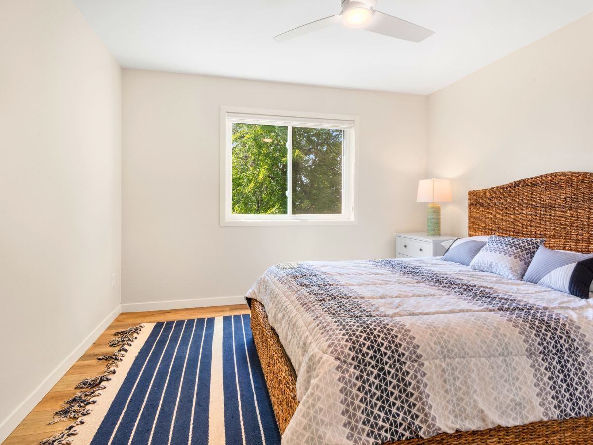 A bedroom with a wicker bed and a window