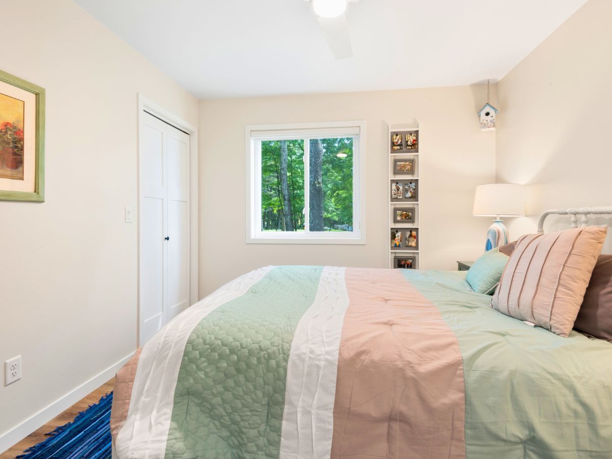 A bedroom with a large bed and a window.