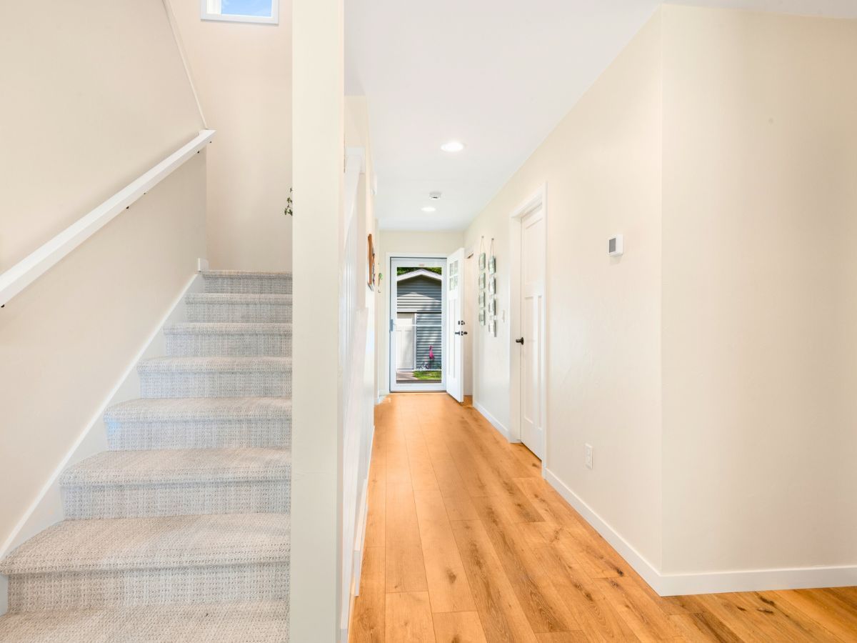 A hallway with stairs leading up to the second floor of a house.