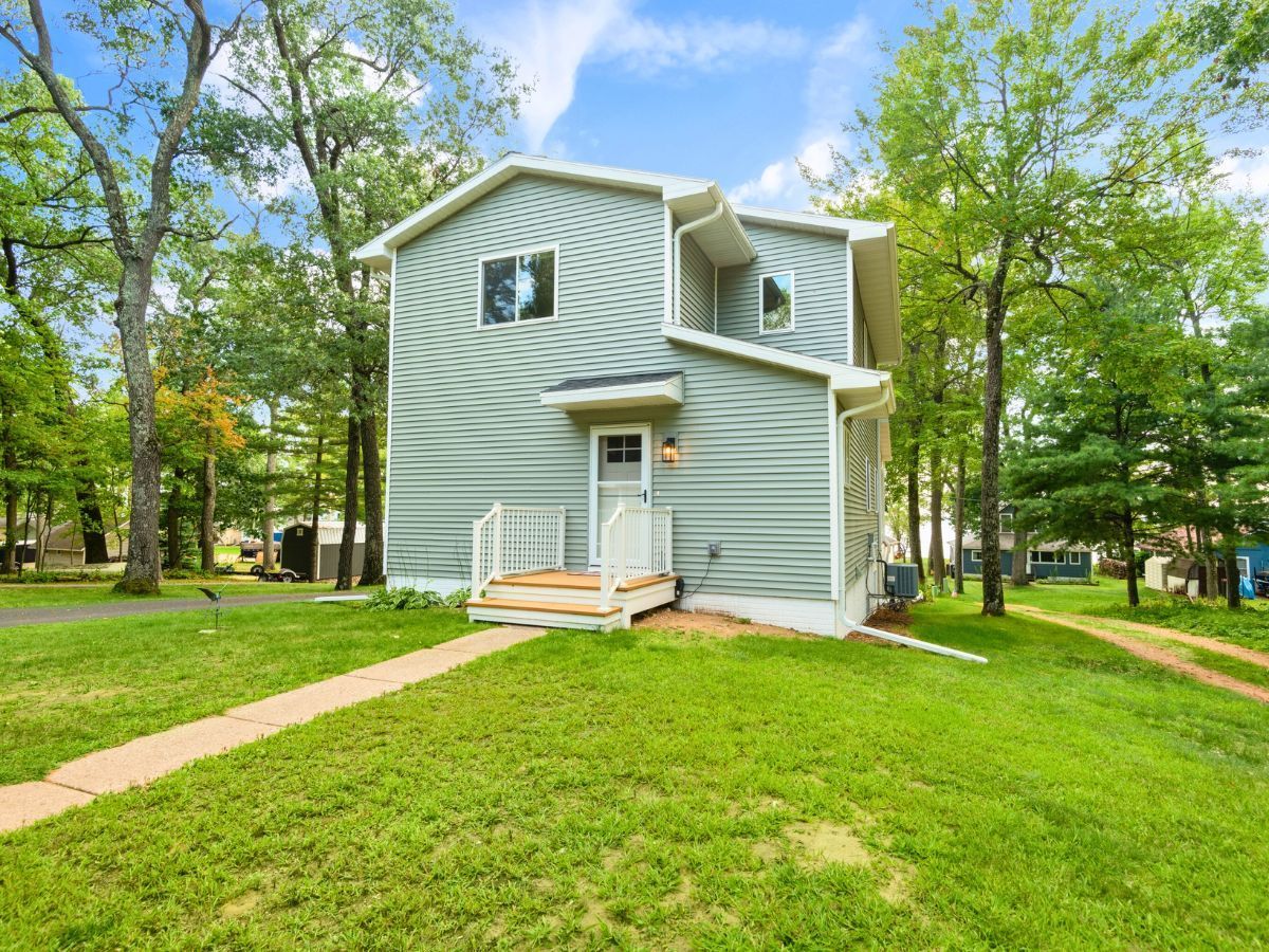 A house with a lot of grass and trees in front of it.