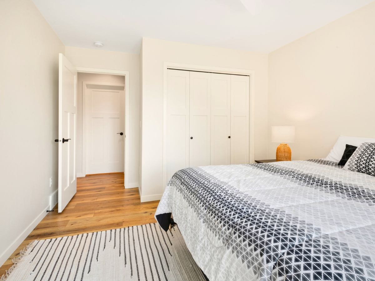 A bedroom with a bed , closet , and rug.