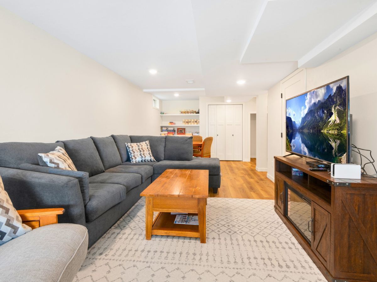 A living room with a large sectional couch and a flat screen tv