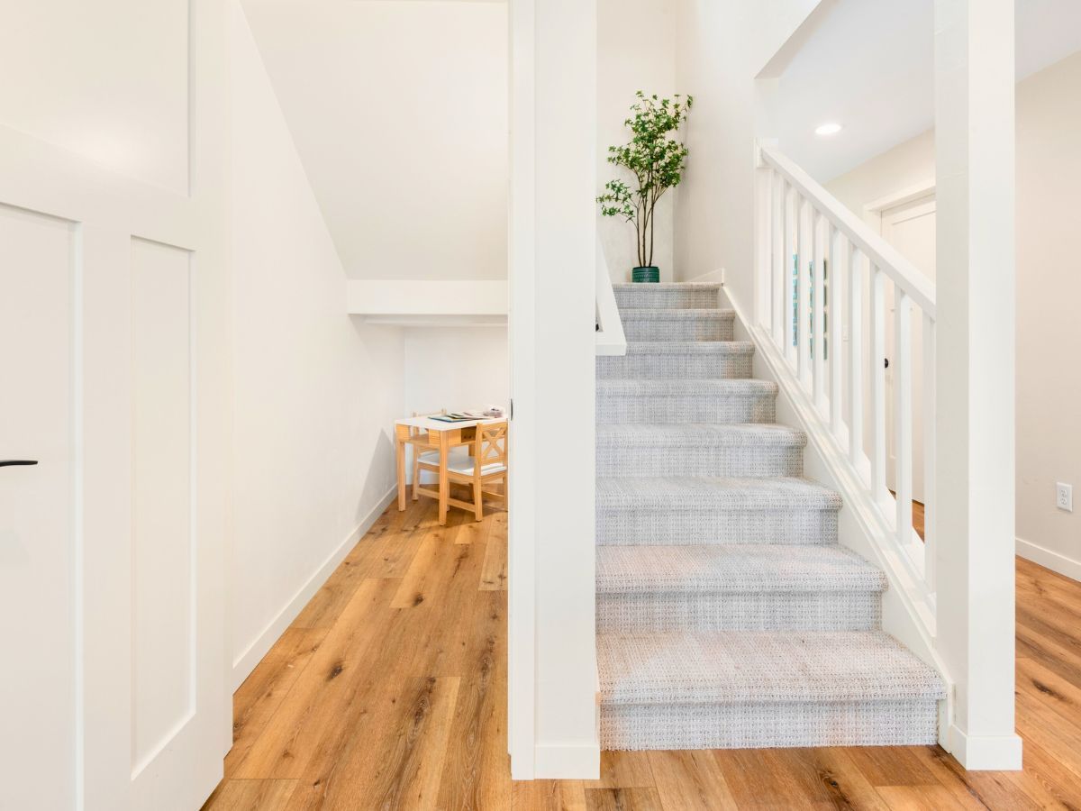 A hallway with stairs leading up to the second floor of a house.