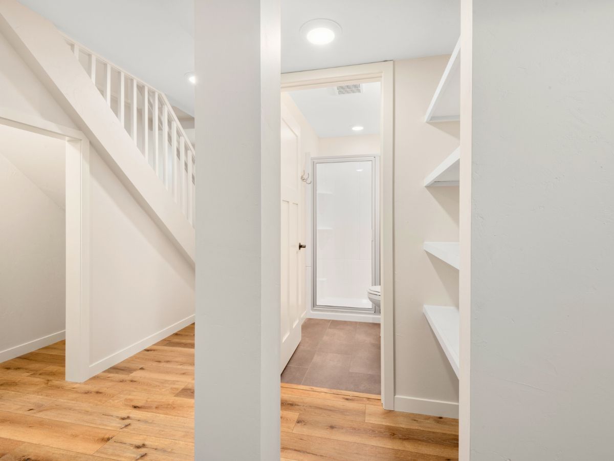 A hallway with a staircase and a walk in closet
