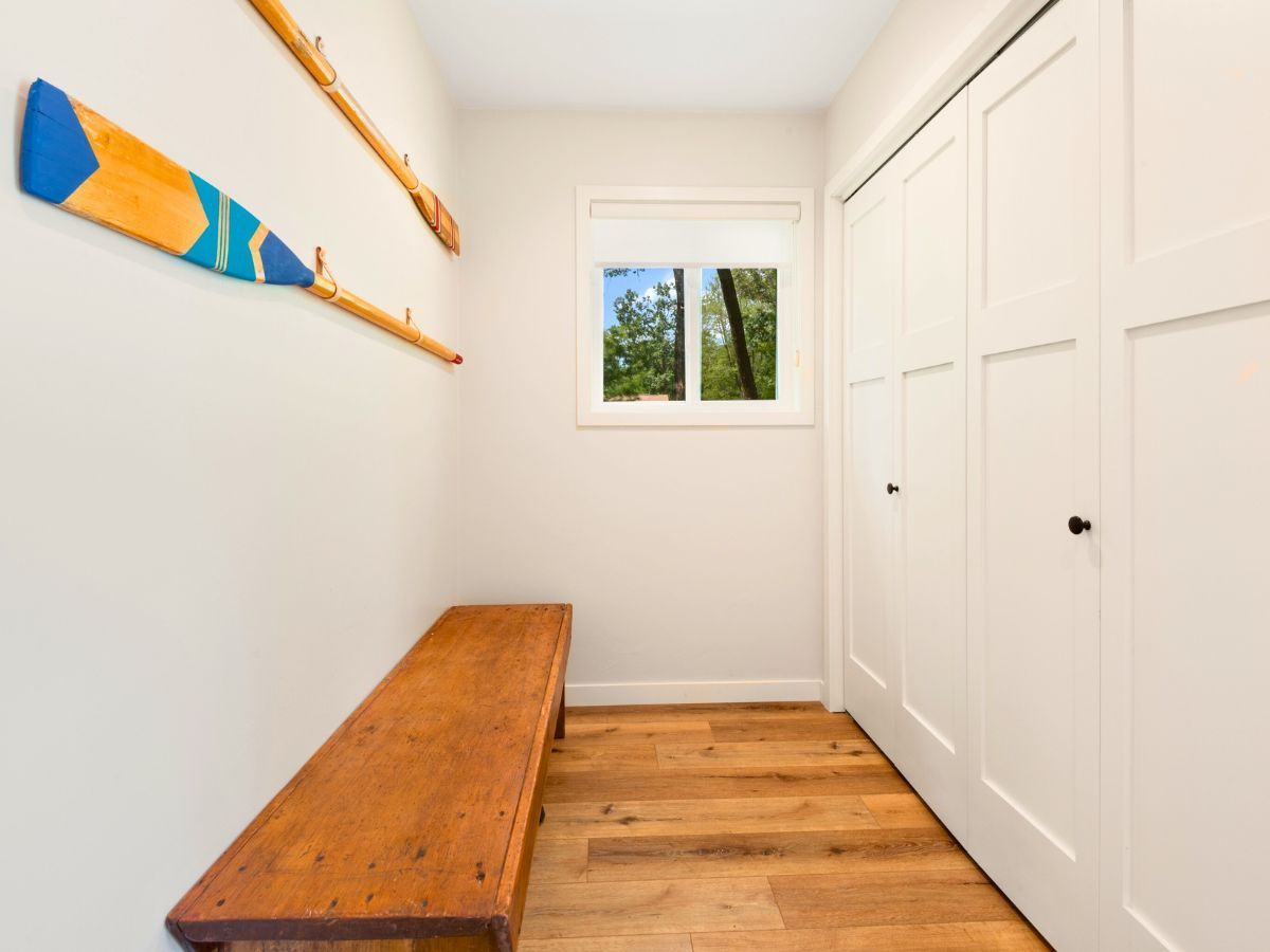 A hallway with a wooden bench and a window