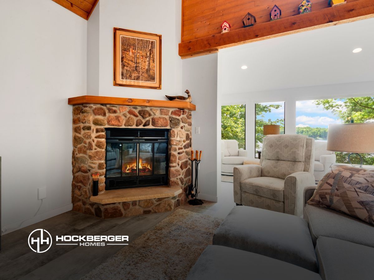 A living room with a stone fireplace and chairs