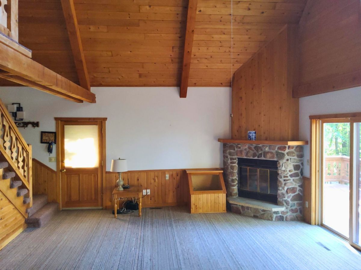 An empty living room with a fireplace and stairs