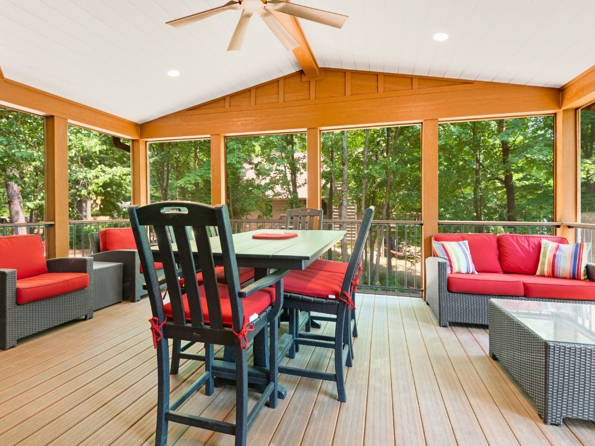 A screened in porch with a table and chairs