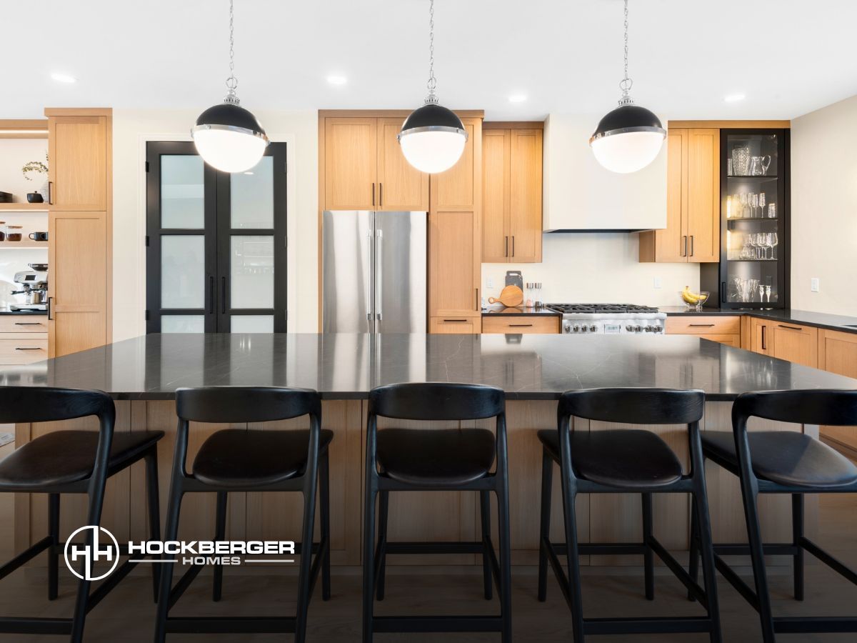 A kitchen with a large island and black chairs