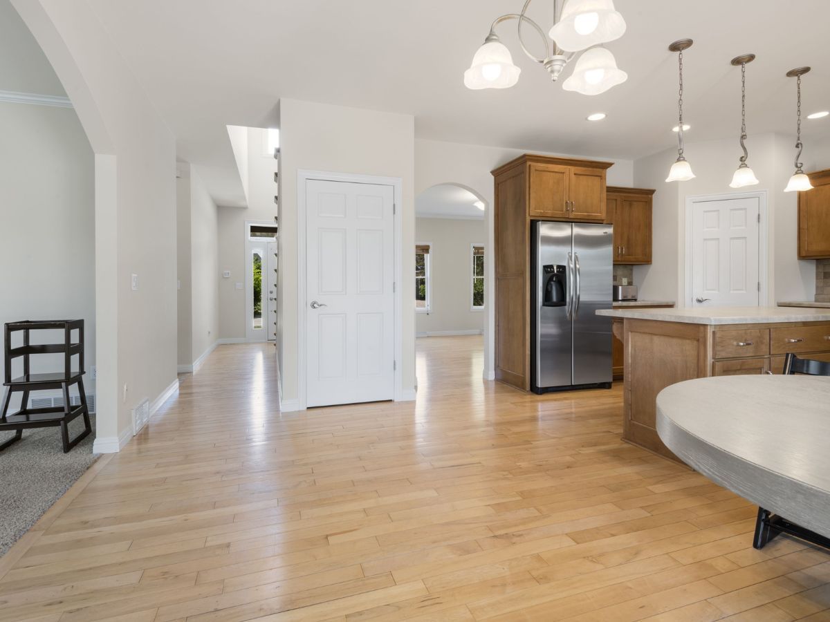 A kitchen with hardwood floors and a stainless steel refrigerator