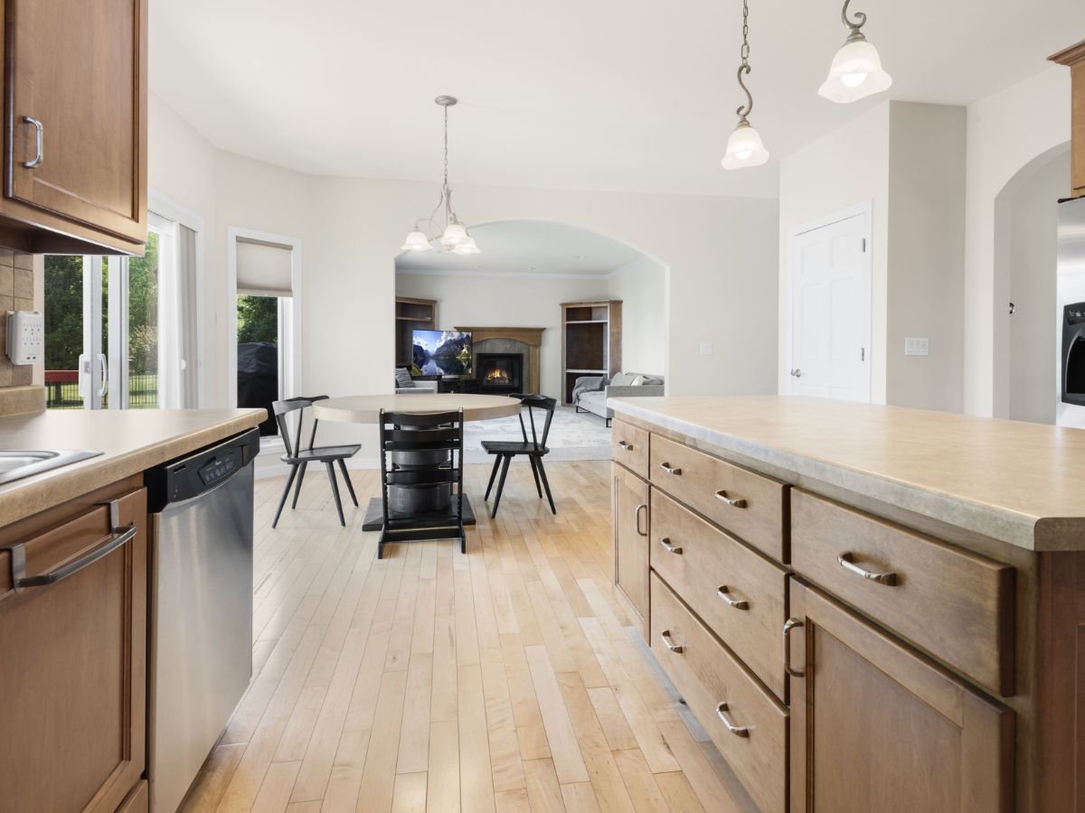 A kitchen with wooden cabinets , stainless steel appliances and a large island.