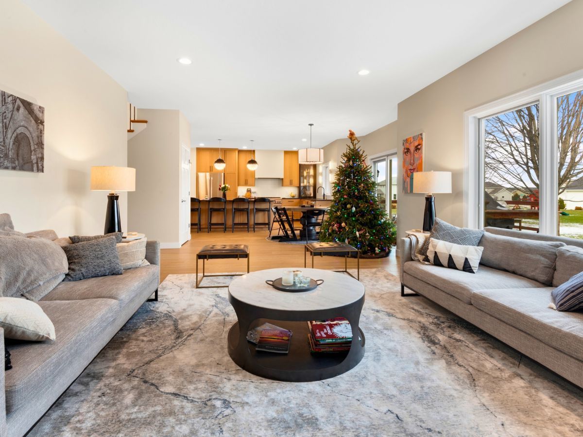 A living room with two couches , a coffee table , and a christmas tree.