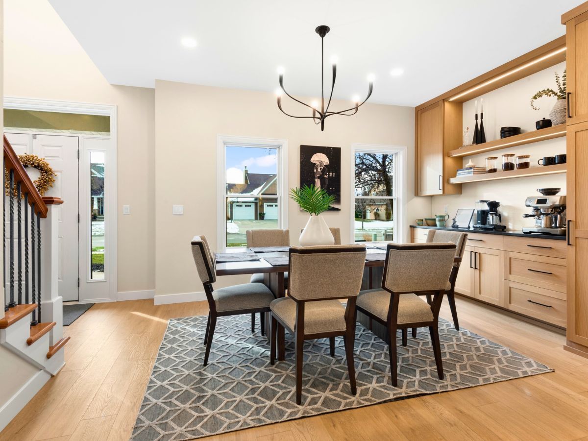A dining room with a table and chairs and a rug