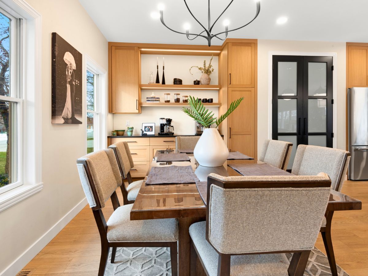 A dining room with a long wooden table and chairs