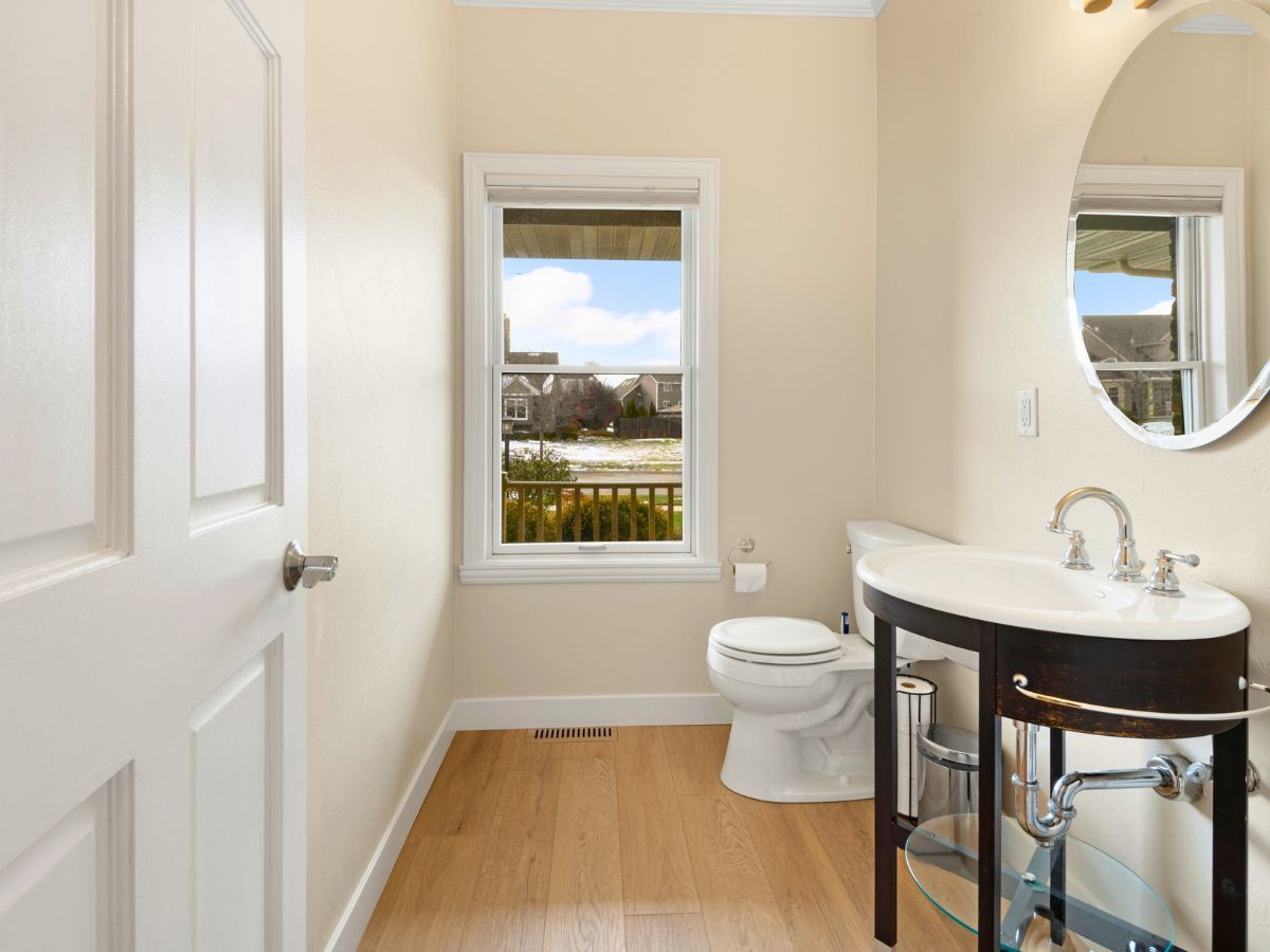 A bathroom with a toilet a sink and a mirror