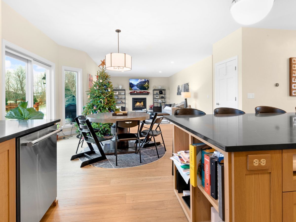 A kitchen with a table and chairs and a christmas tree in the background.