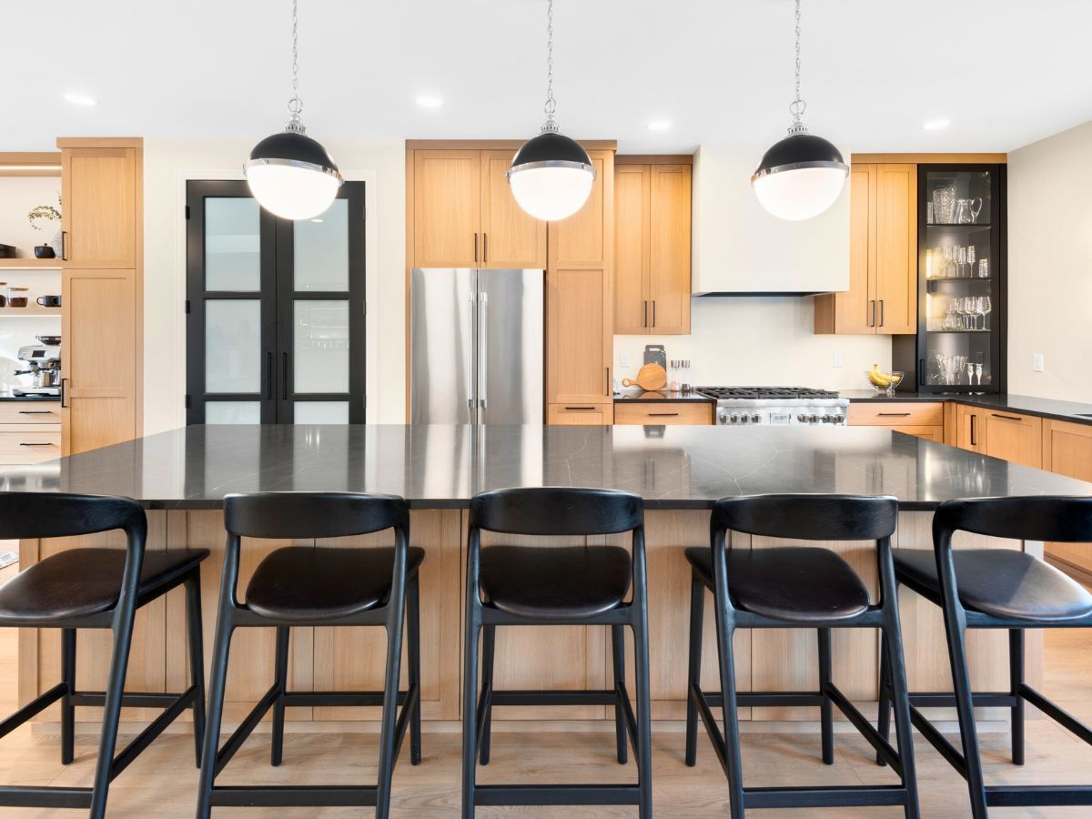 A kitchen with a large island and black chairs