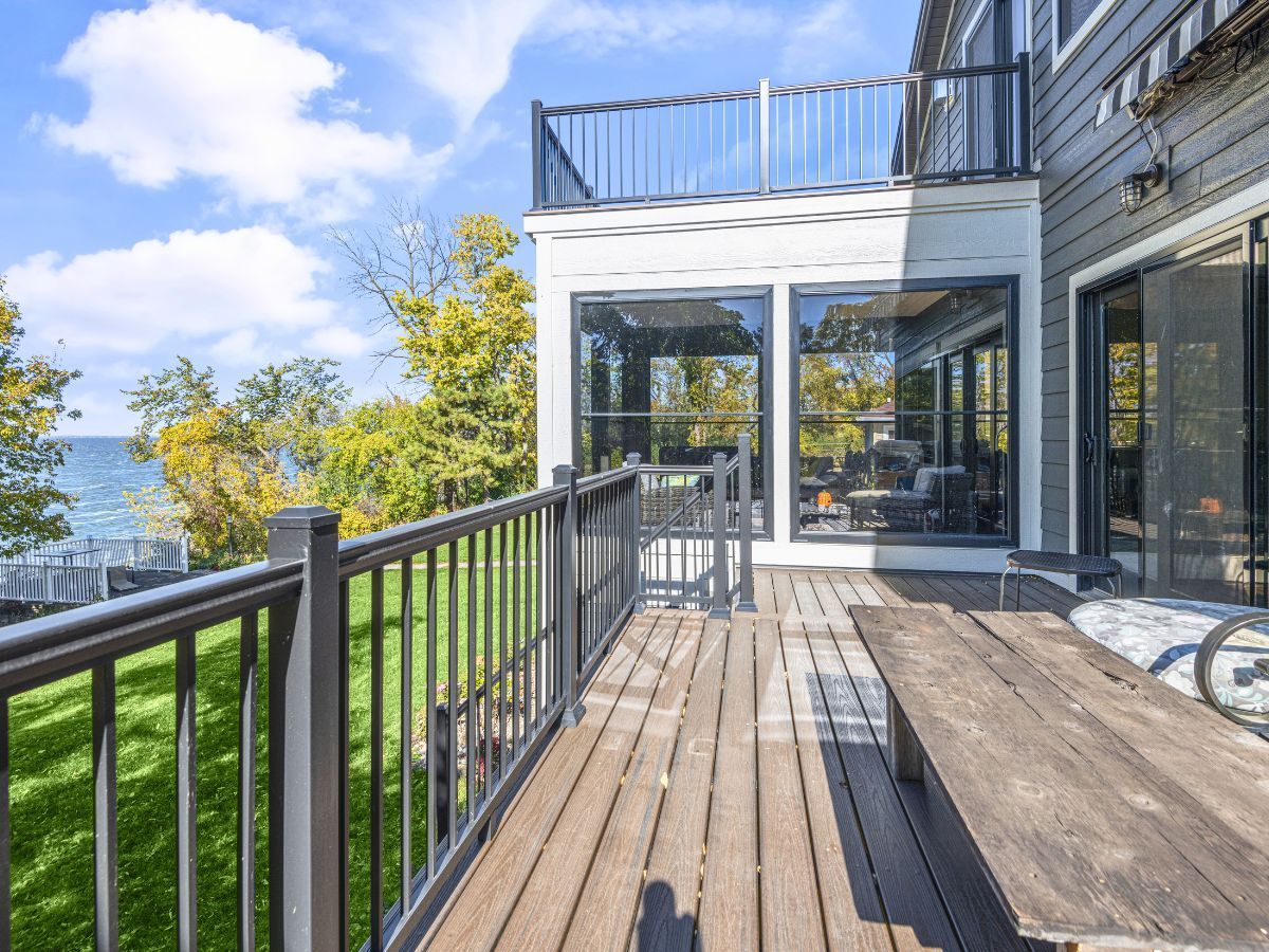 A large deck with a picnic table and a view of the ocean.