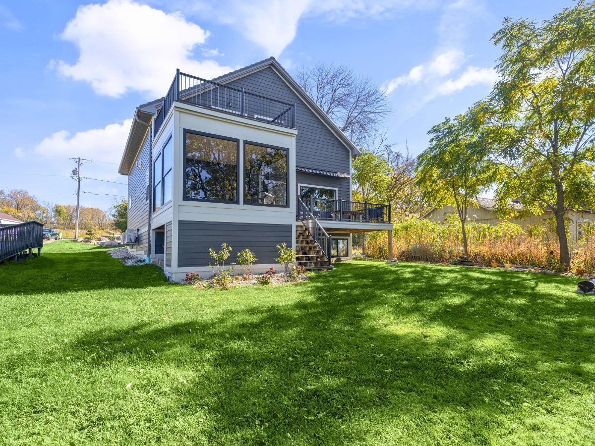 The back of a house with a large lawn in front of it.
