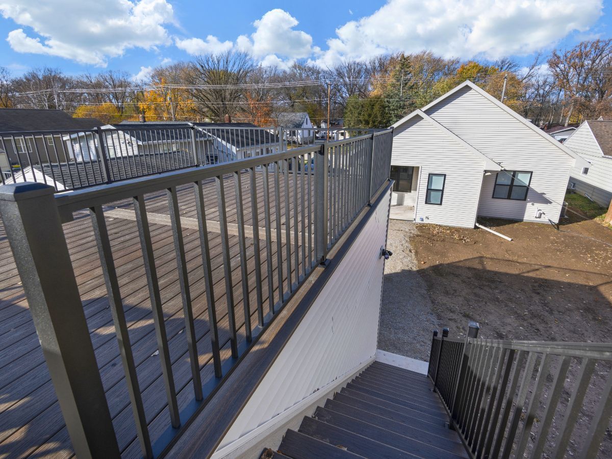 A staircase leading up to a house with a metal railing
