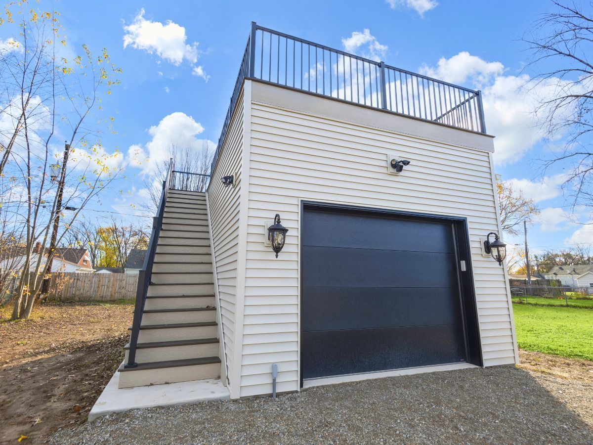 A garage with stairs leading up to it and a balcony.