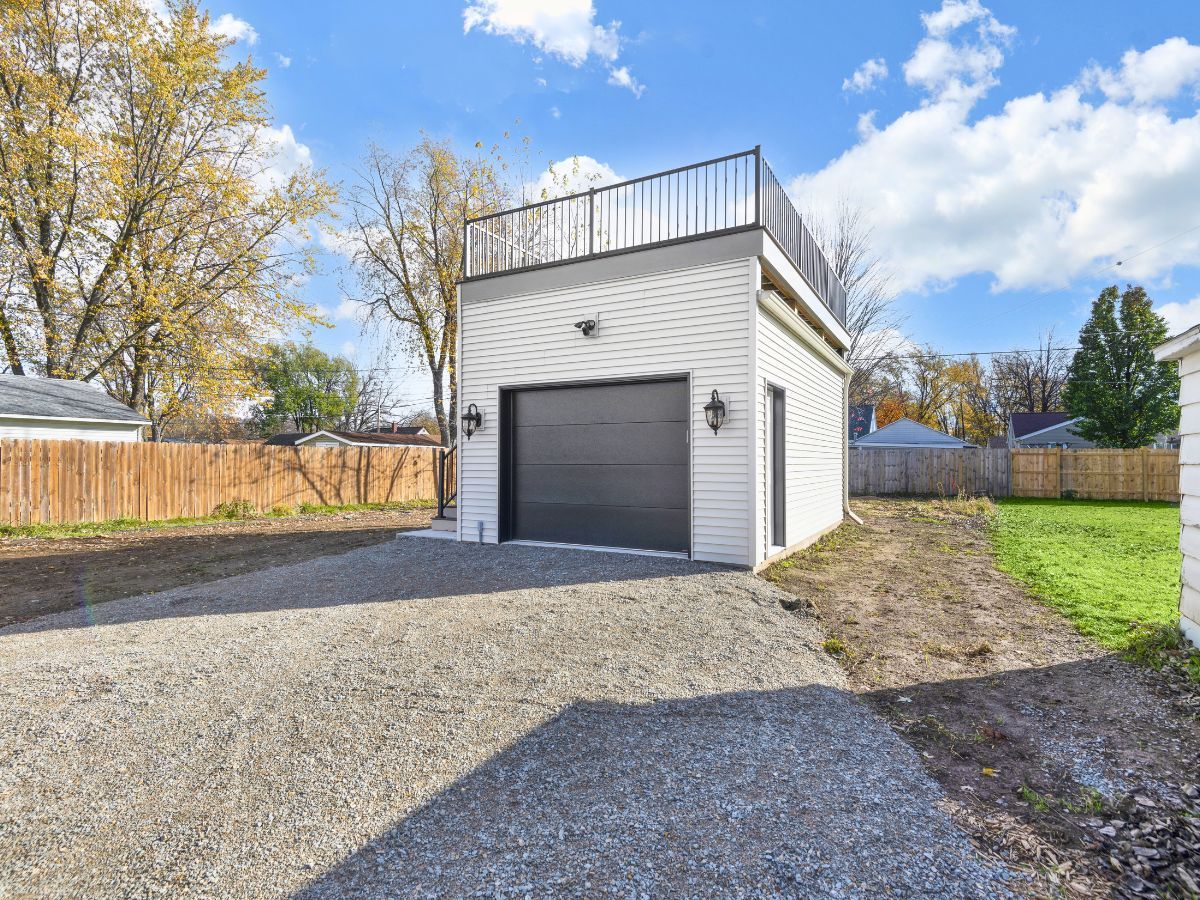 There is a garage with a balcony on top of it.