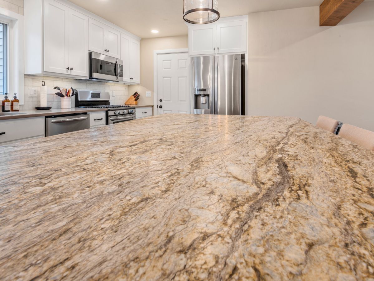 A kitchen with granite counter tops and stainless steel appliances.
