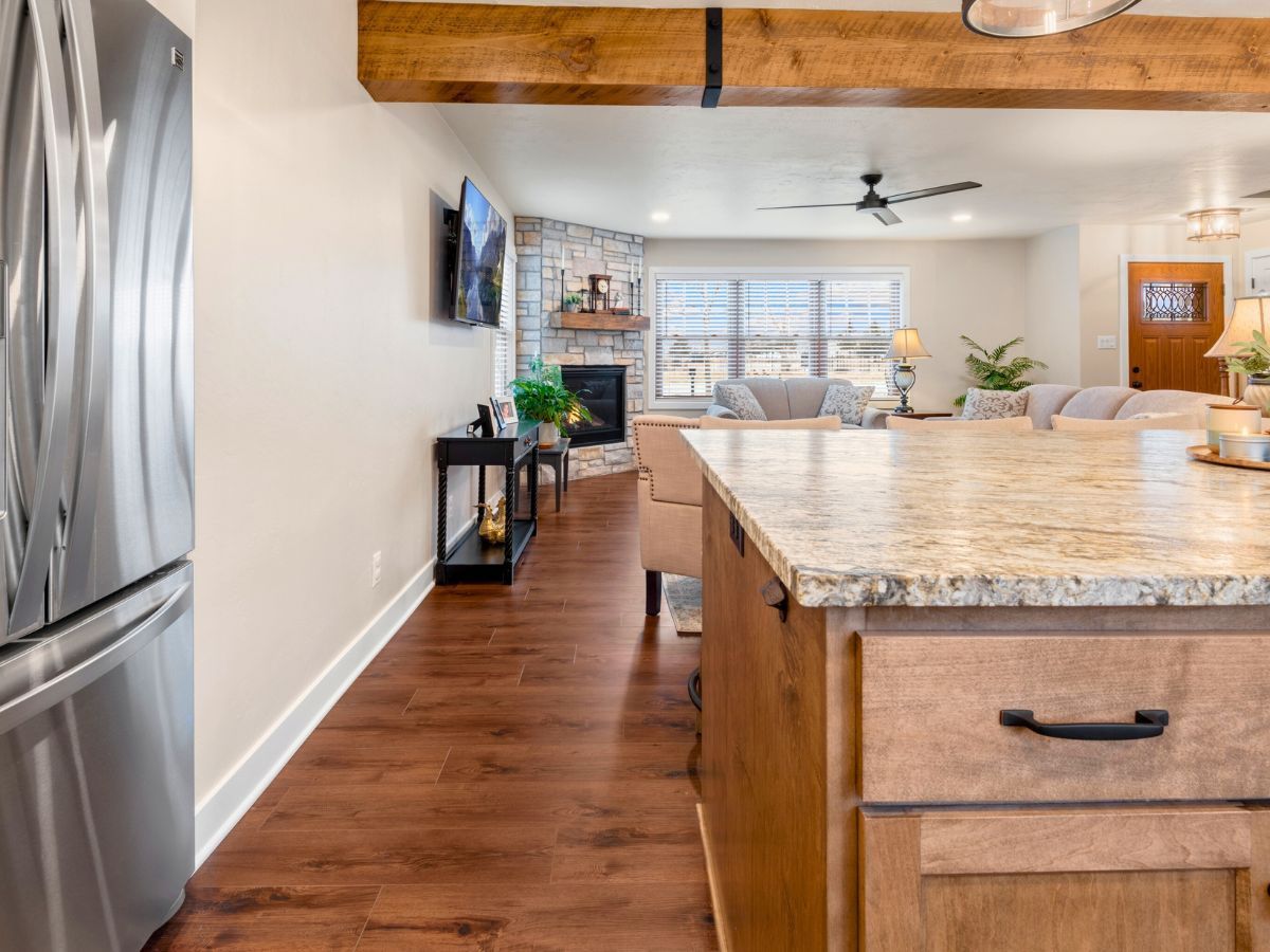 A kitchen with a stainless steel refrigerator and a granite counter top.