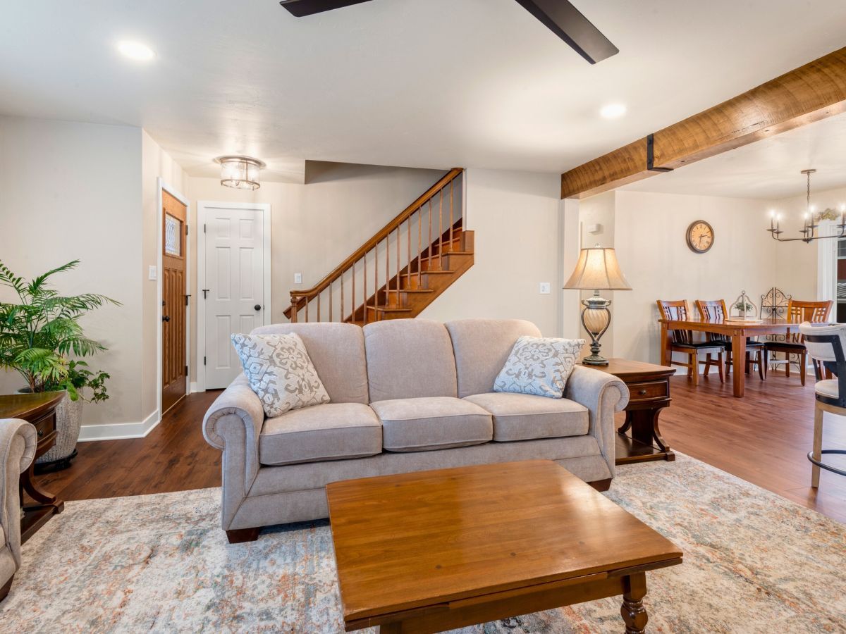 A living room with a couch , coffee table , and stairs.