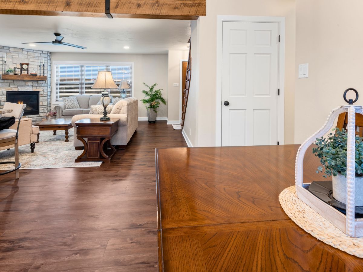 A living room with hardwood floors and a wooden table in the foreground.