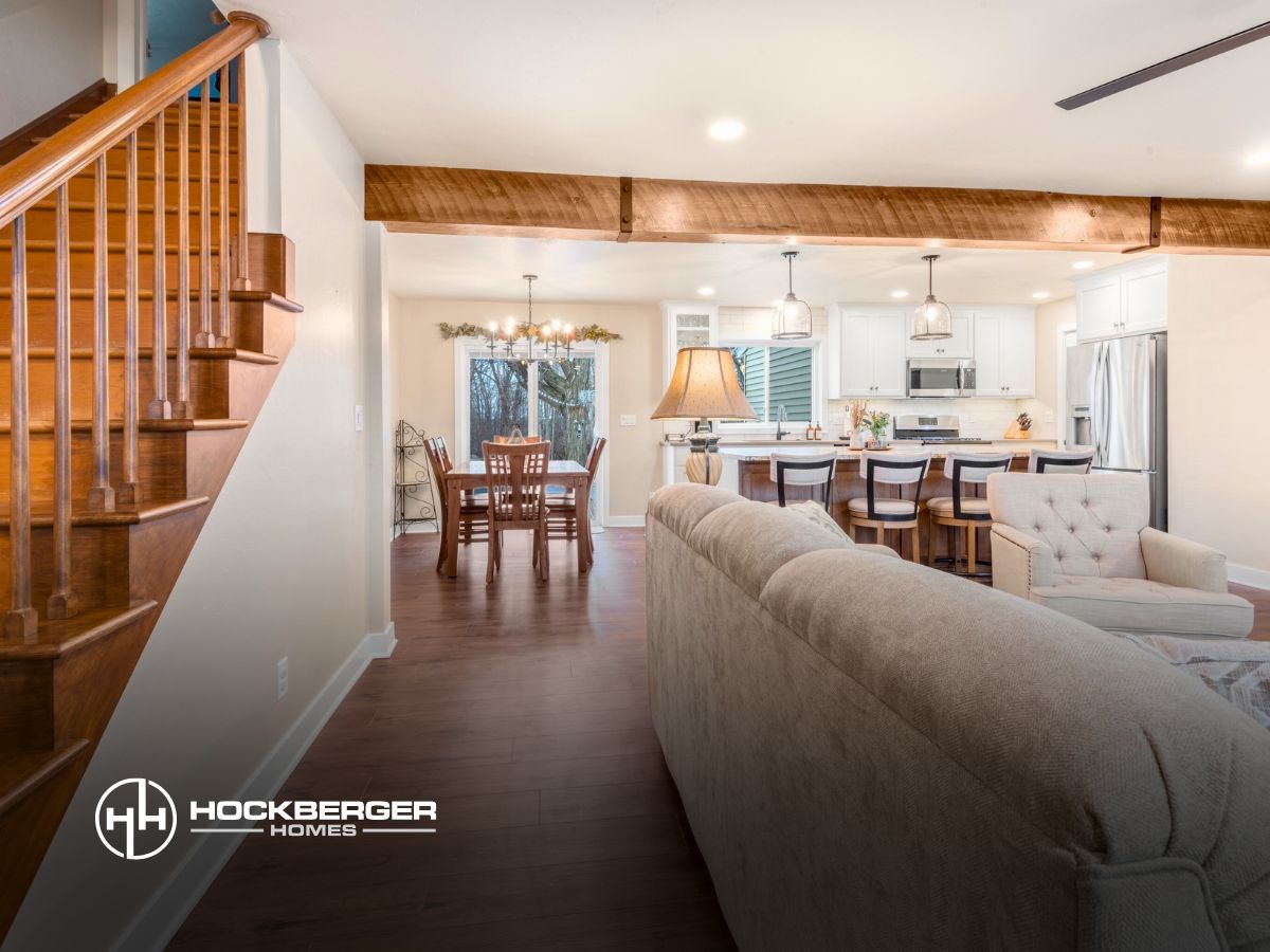 A living room with a couch and stairs leading to the kitchen