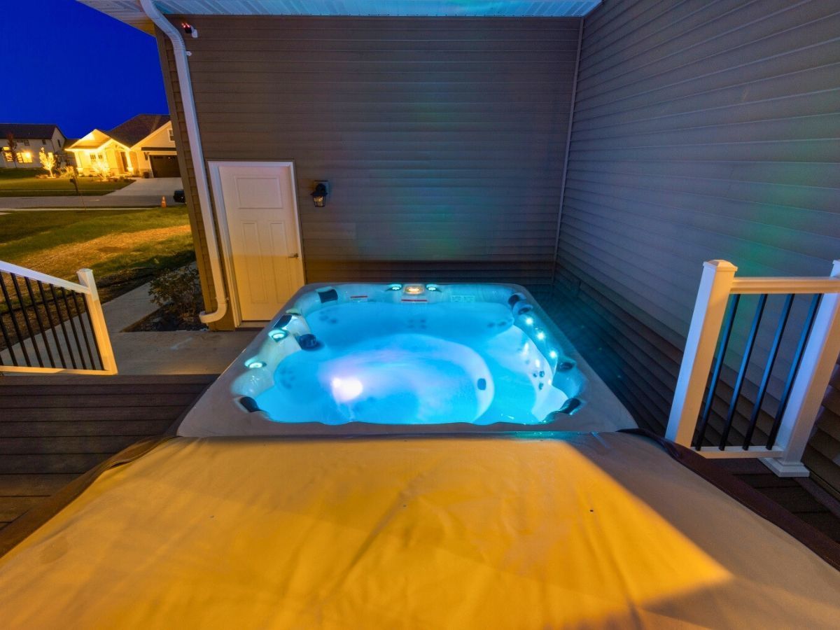 A hot tub on a deck with blue lights on it