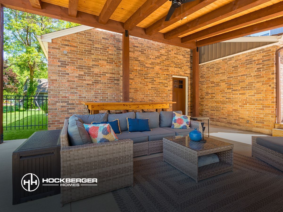 A living room with a couch and a table under a wooden roof.