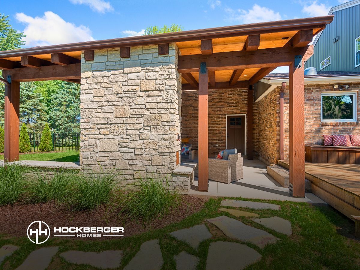 A stone building with a wooden pergola over it