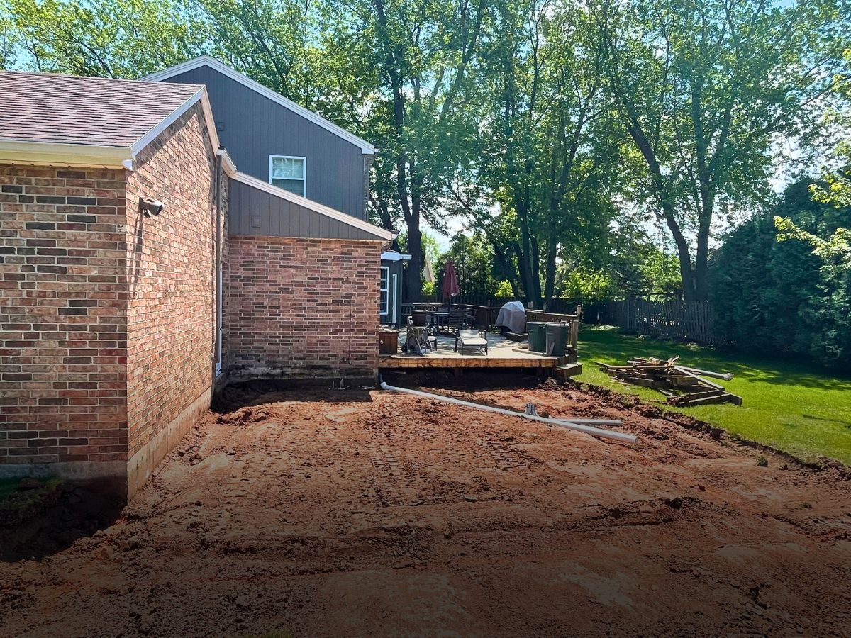A brick house with a deck in the backyard.