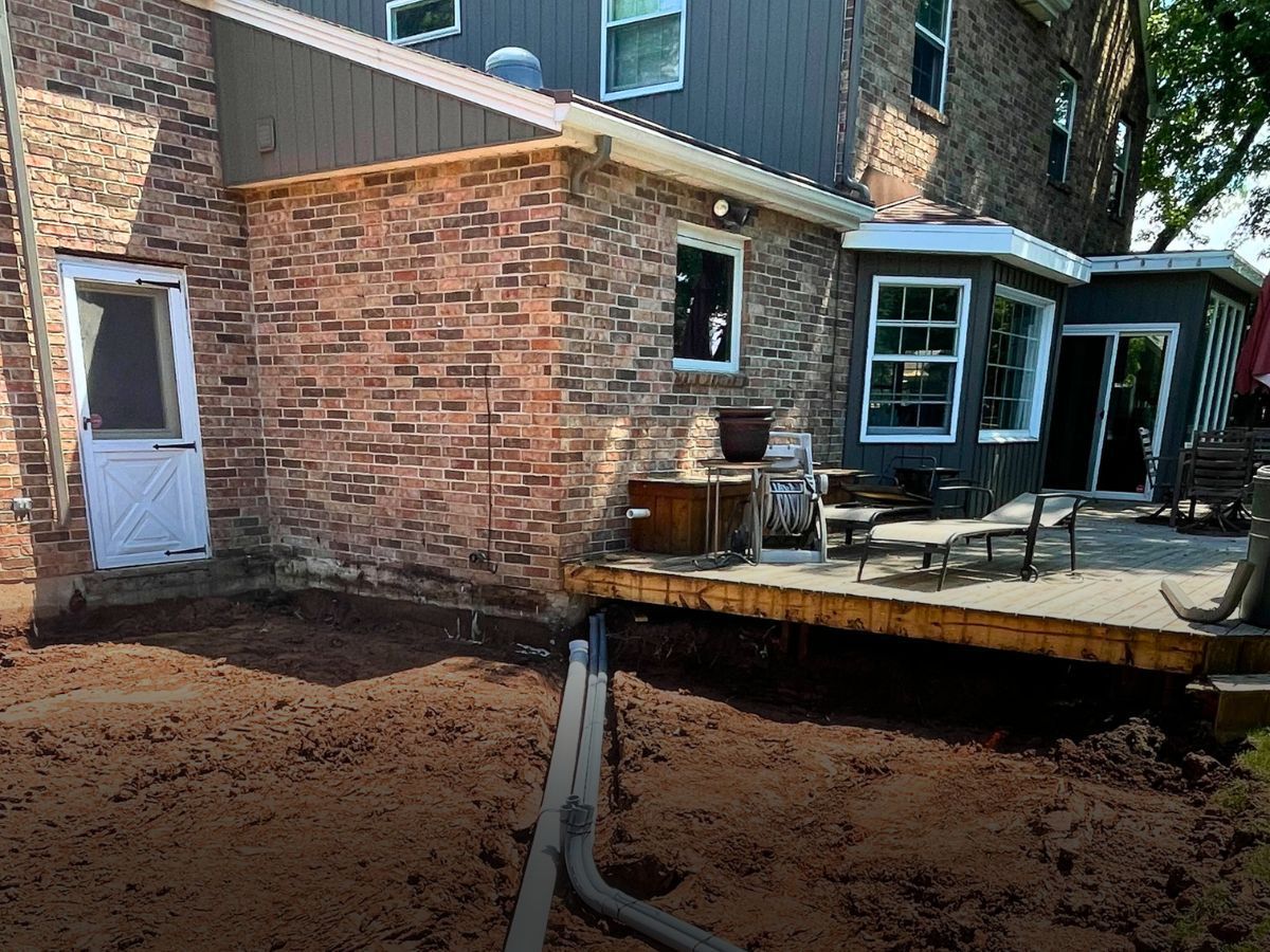 A brick house with a wooden deck in front of it.