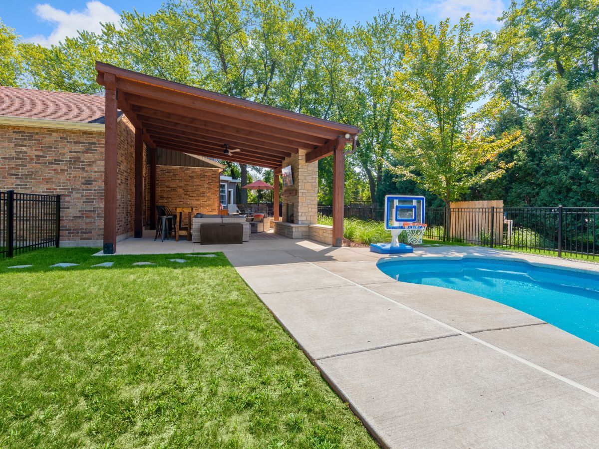 There is a large swimming pool in the backyard of a house.