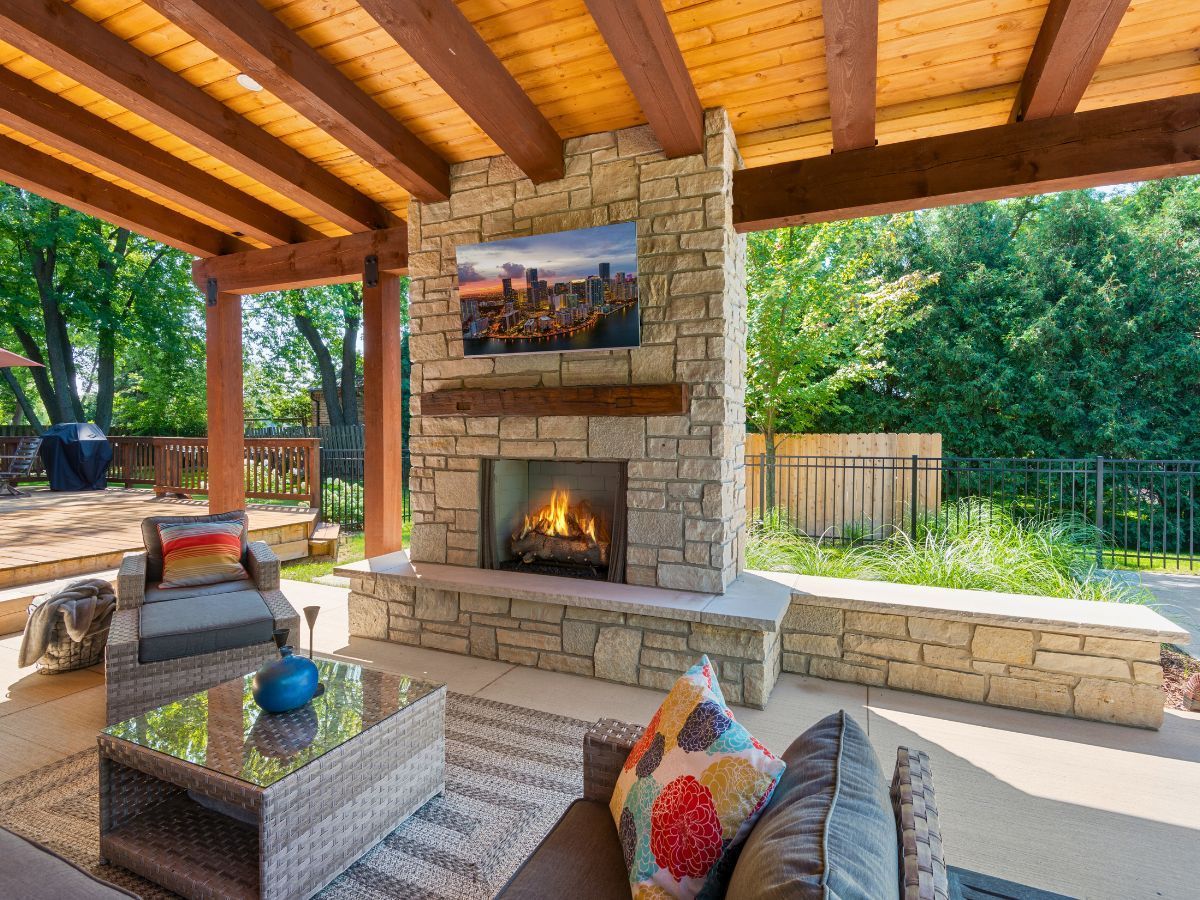A living room with a fireplace and a television on the wall.
