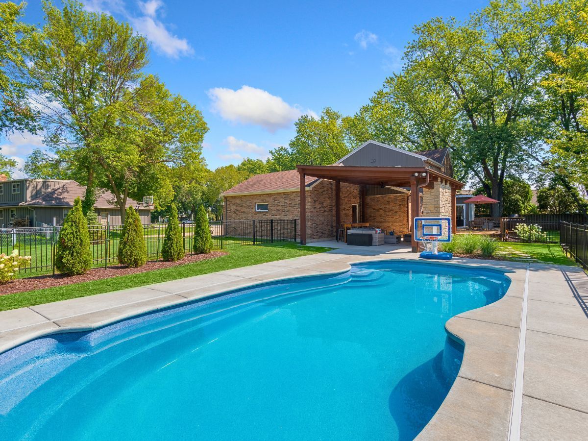 A large swimming pool in the backyard of a house