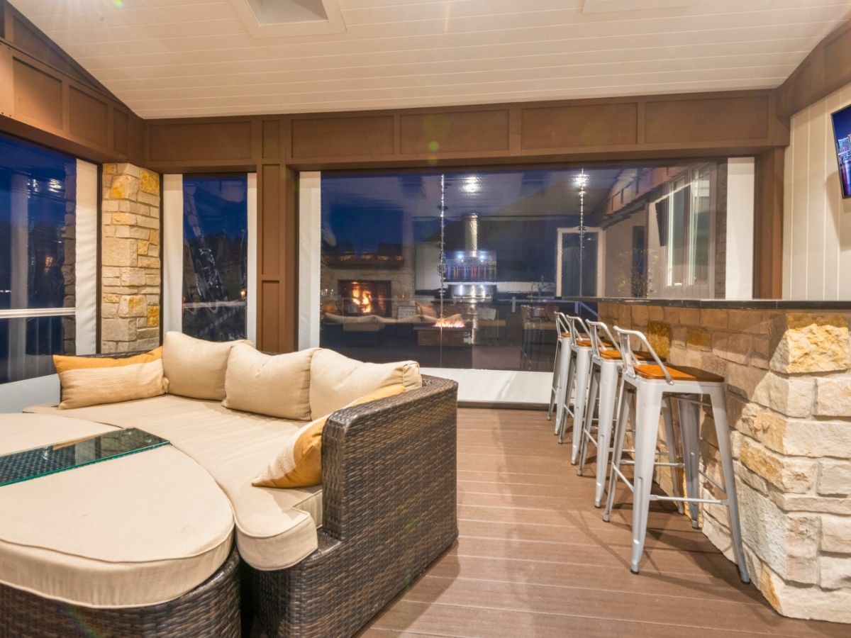 A living room with a couch and stools and a large window.