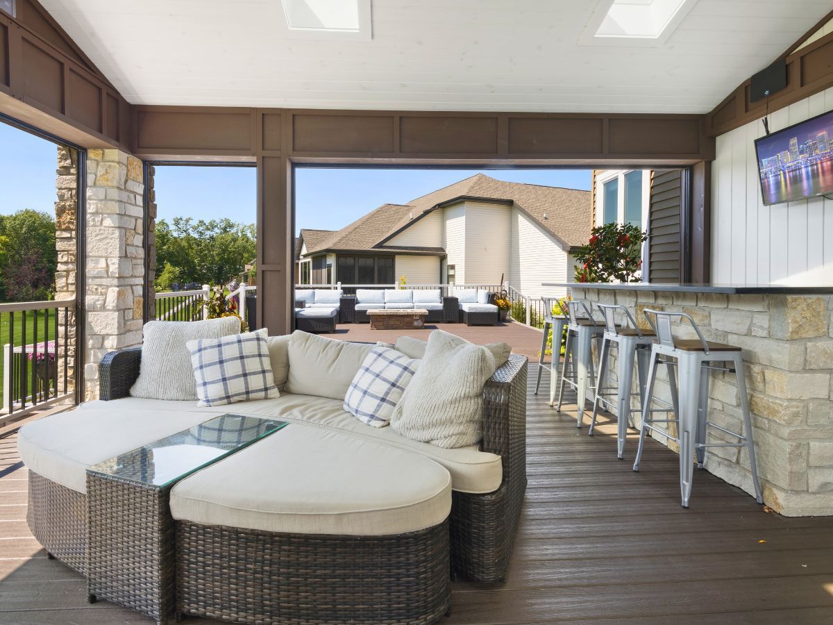 A living room with a couch , table , stools and a television.