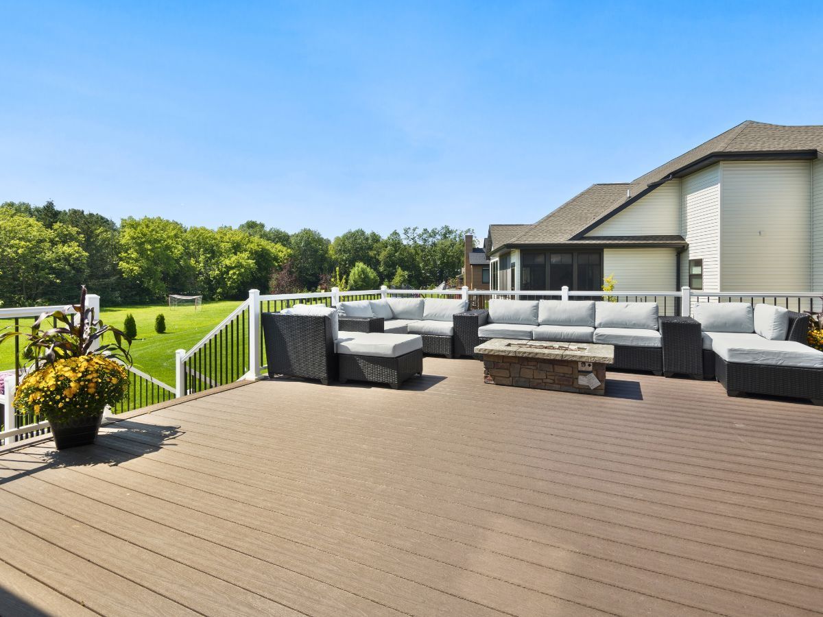 There is a large deck with a lot of furniture on it.