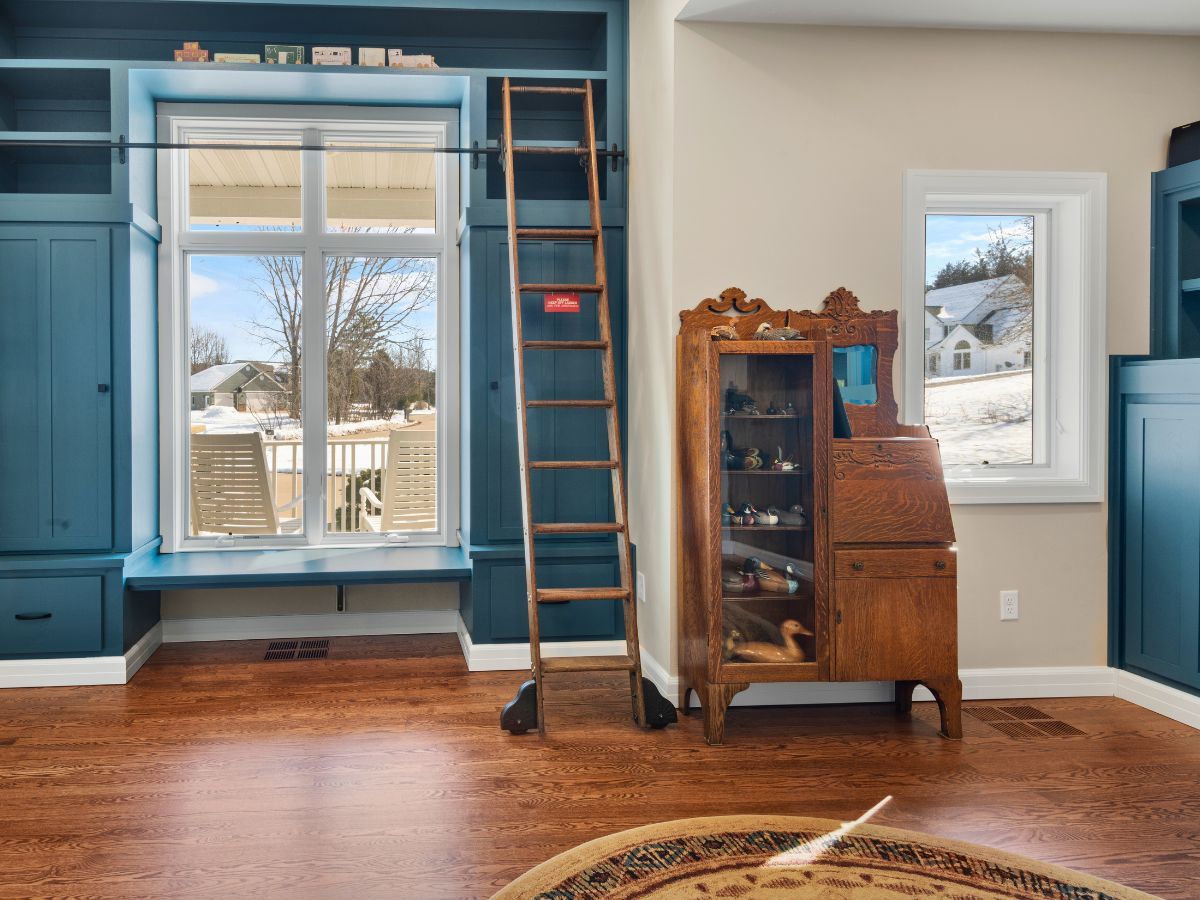 A living room with a ladder and a desk