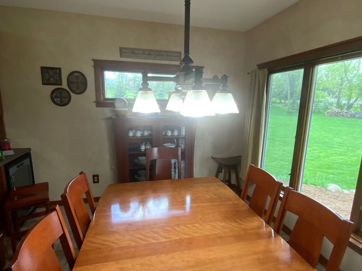 A dining room with a table and chairs and a chandelier hanging from the ceiling
