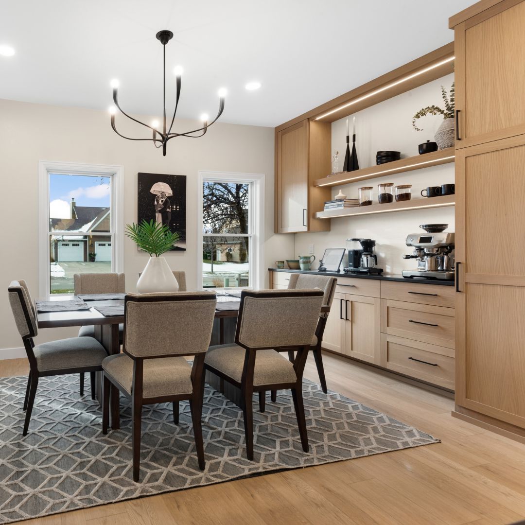 A dining room with a table and chairs and a rug