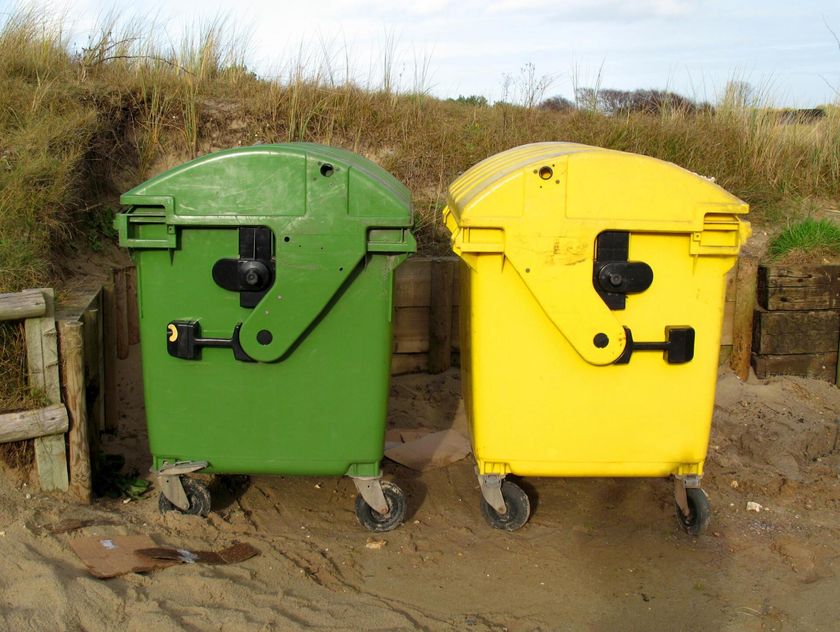 two dumpsters in the sand