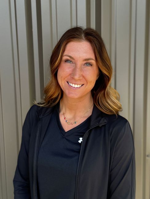A woman wearing a black shirt is smiling for the camera