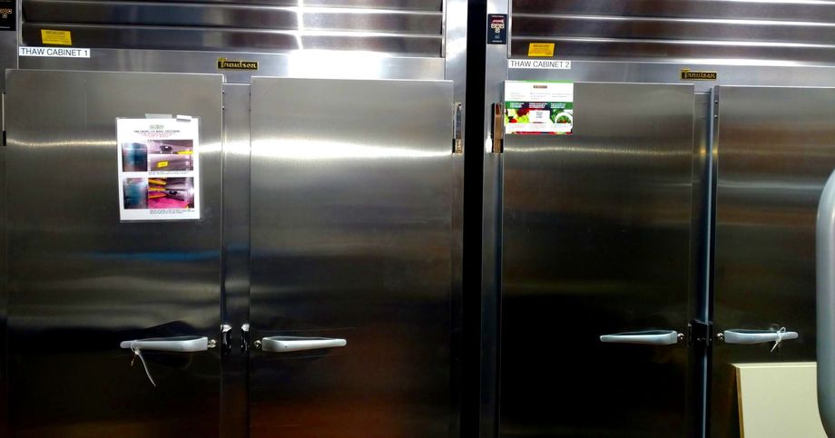Two stainless steel refrigerators are lined up next to each other