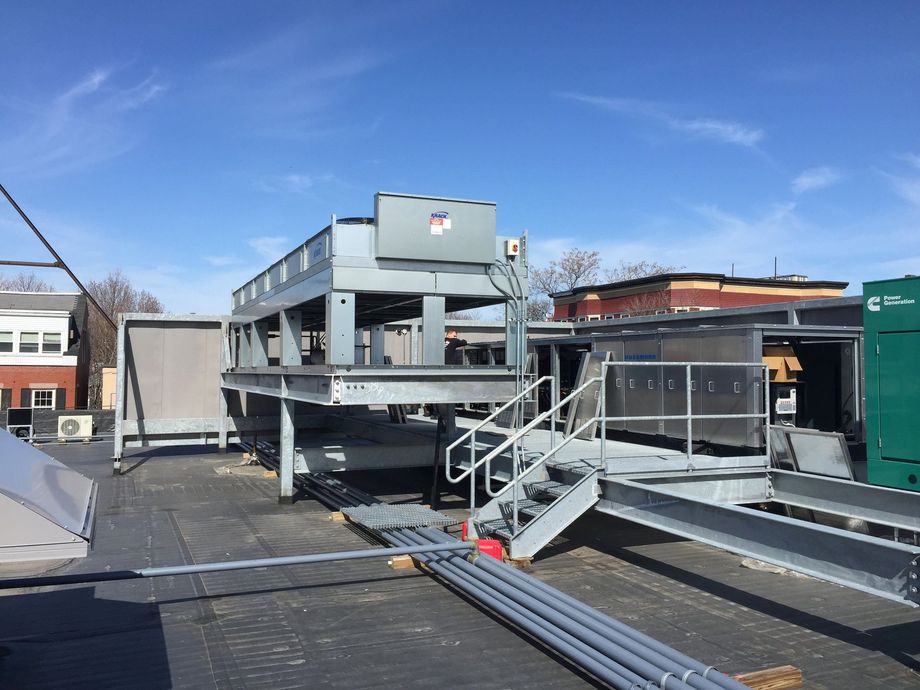 A large metal structure on top of a building with stairs leading up to it.